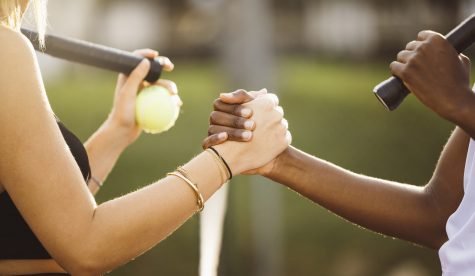 Amateur tennis players shaking hands at the net. Two sportswomen shaking hands over the net after the match.
